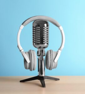 Retro,Microphone,And,Headphones,On,Table,Against,Blue,Wall | Podcast Marketing for Brands | | Site Hub