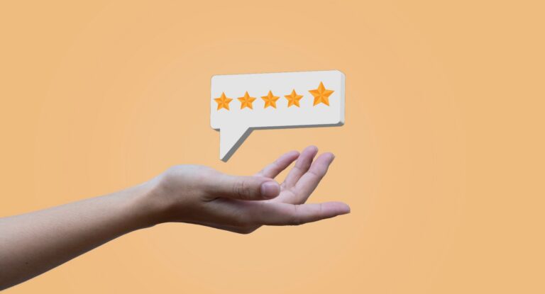 A hand holding a speech bubble containing a five star rating